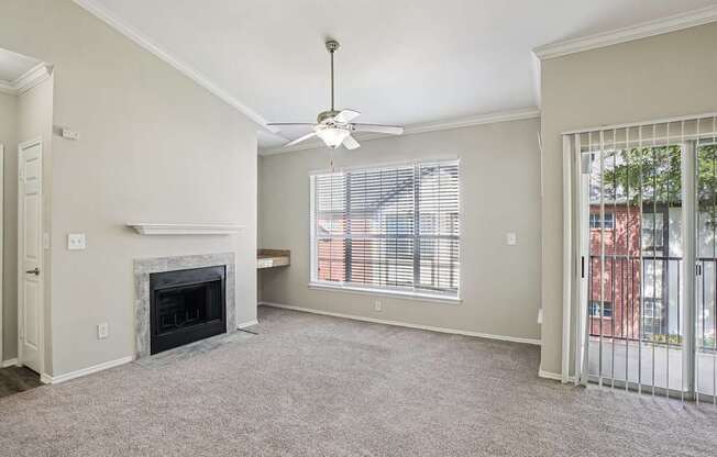 A living room with a fireplace and a ceiling fan.