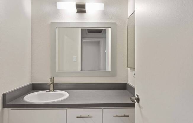 A bathroom with a sink and a mirror.