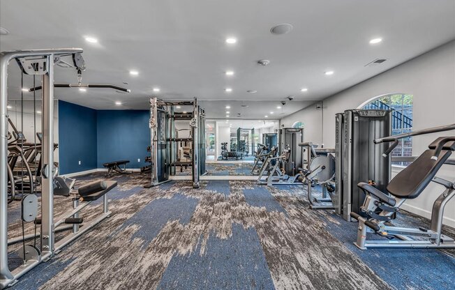 a gym with weights and cardio equipment in a building with blue walls