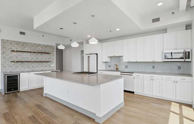 a large white kitchen with a large island and white cabinets