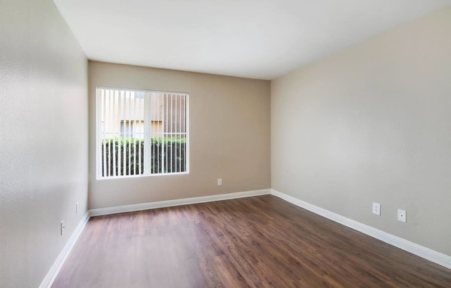 Empty living room with wood floors and a window at Ascend2300, Carlsbad