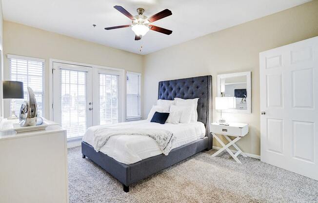 a bedroom with a bed and a ceiling fan