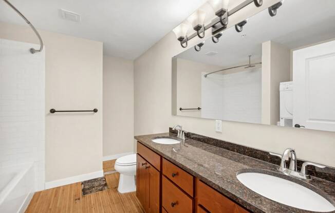 a bathroom with two sinks and a mirror and a toilet