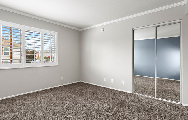 Carpeted bedroom with private sliding door closets.