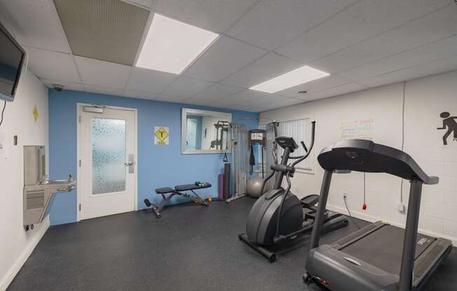 a gym with treadmills and other exercise equipment inside of a building