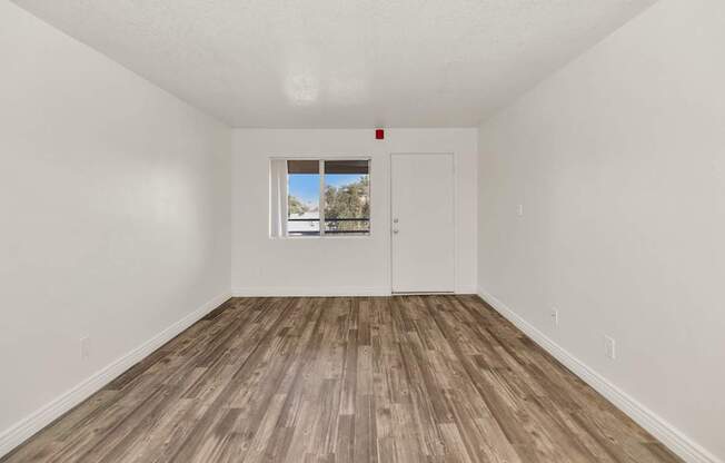 A room with a white door and a window with a view of trees and a house at Urban WalkApartments on 6th Avenue, Phoenix, AZ
