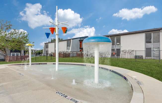 a fountain in a courtyard with buildings in the background