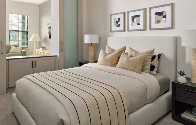 A bedroom with a large bed and a nightstand with a lamp.