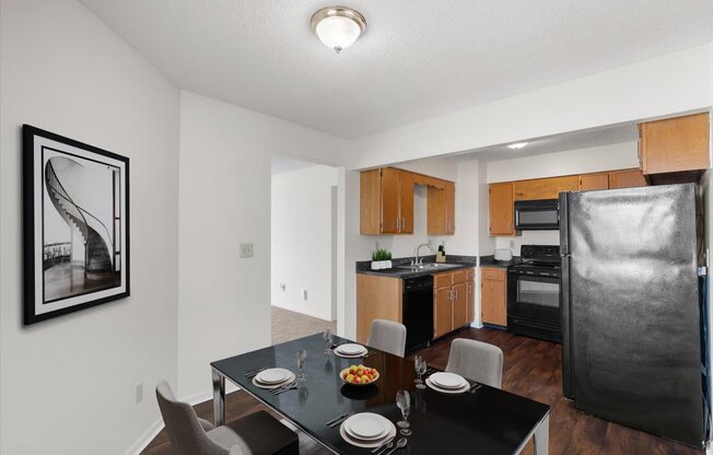 a kitchen and dining room with a black table and chairs