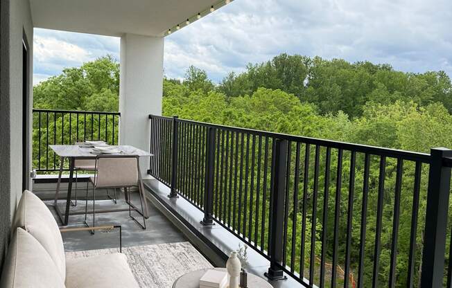 Altura balcony with a table and chairs overlooking a green landscape