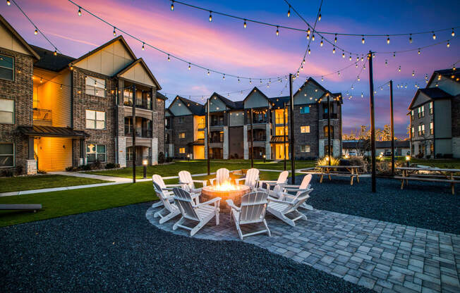 a patio with a fire pit and chairs at the enclave at woodbridge apartments in sugar land