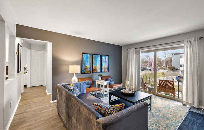 A living room with a couch, a chair, a coffee table, and a painting on the wall.
