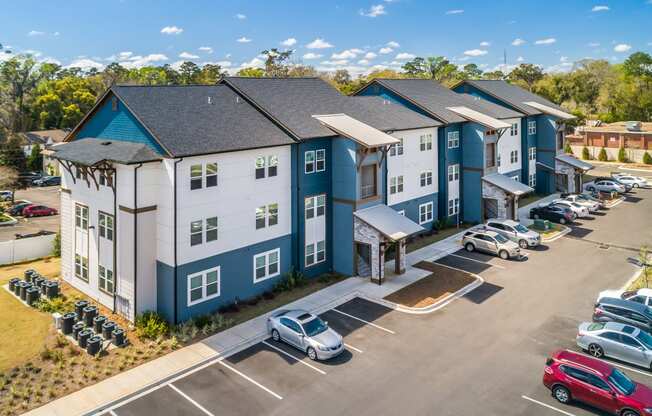 an aerial view of a large apartment complex with cars parked in the parking lot