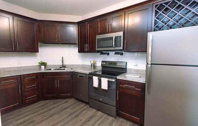 A kitchen with dark wood cabinets and a white refrigerator.