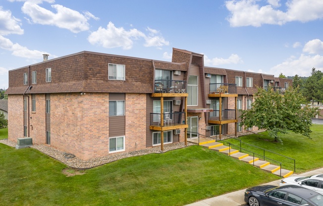 A modern brick building with a green lawn in front.