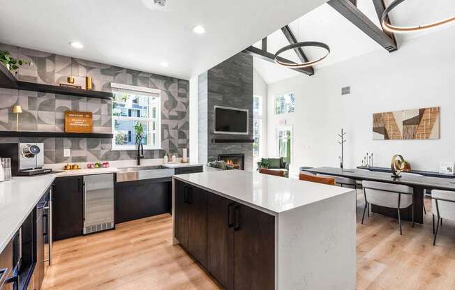A modern kitchen with a large island and a dining table.