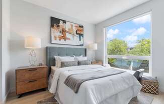 a bedroom with a bed and a large window