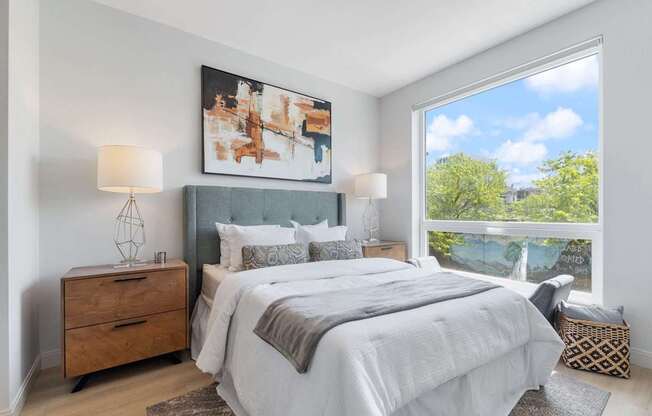 a bedroom with a bed and a large window