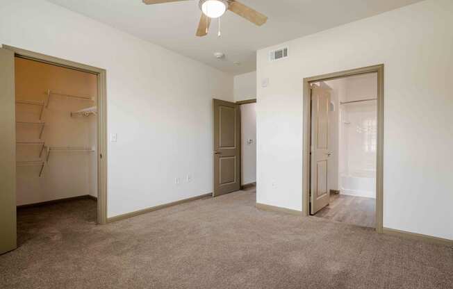 A bedroom with a ceiling fan and doors