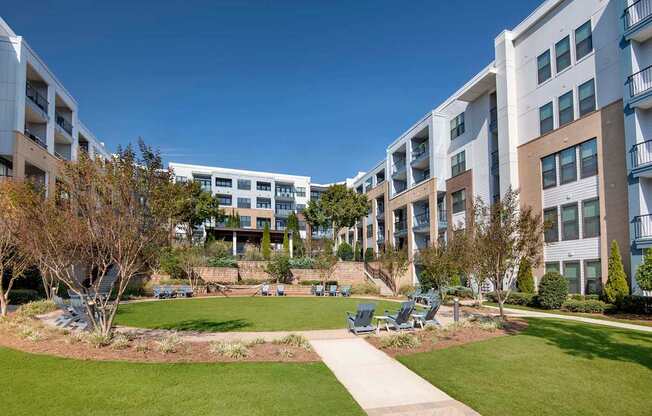 A sunny day at a residential complex with a well-maintained lawn and trees.