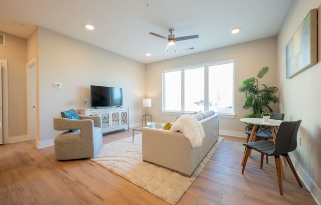 a living room with a couch and chairs and a tv