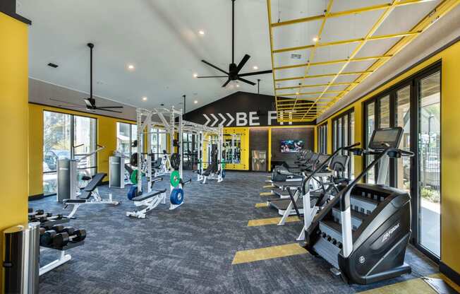 a gym with treadmills and other exercise equipment in the lobby of a building