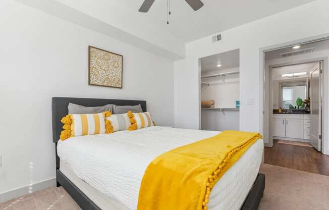 a bedroom with a large white bed and a yellow blanket