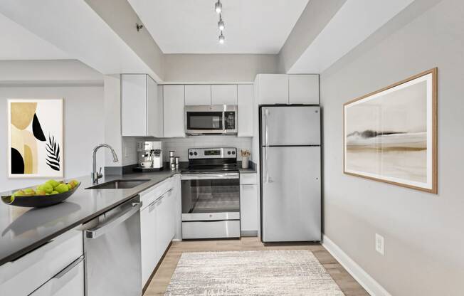 a modern kitchen with stainless steel appliances and white cabinets