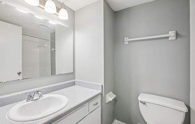 A white toilet sits next to a white sink in a bathroom.