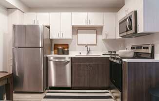 a kitchen with stainless steel appliances and white cabinets