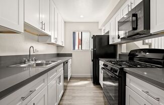 a kitchen with black appliances and white cabinets