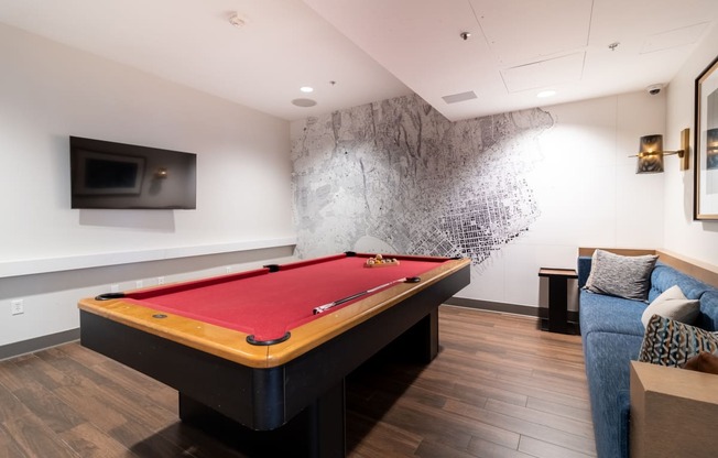 a billiards table in a living room with a red pool table