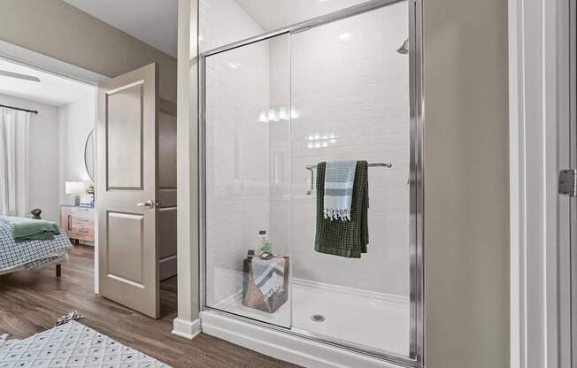 A bathroom with a glass shower door and a towel hanging on it.