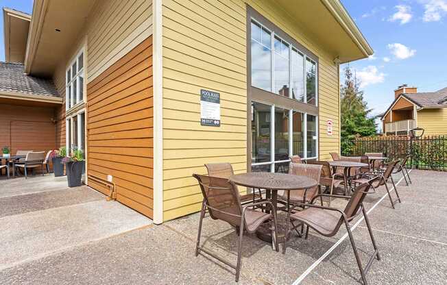 A yellow house with a patio table and chairs.
