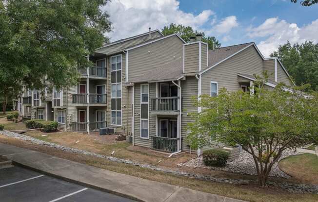 exterior view of an apartment building with sidewalks and trees