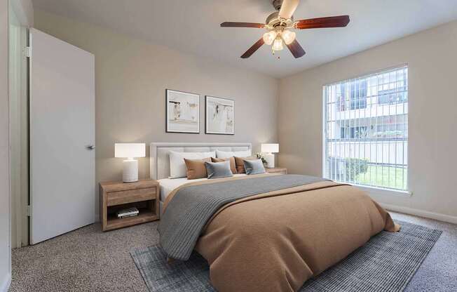 A bedroom with a large bed and a ceiling fan.