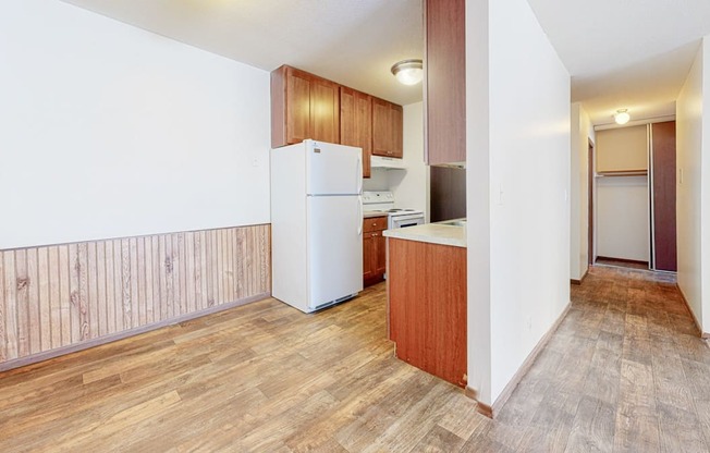 a kitchen with a white refrigerator freezer next to a white stove top oven