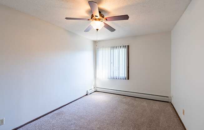 a bedroom of an empty apartment with a ceiling fan. Eagan, MN Glen Pond Apartments