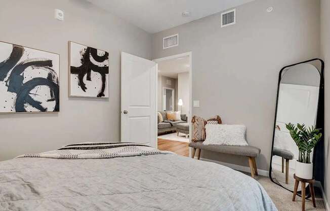 a bedroom with a bed and a mirror.. Circle Pines, MN Lexington Lofts