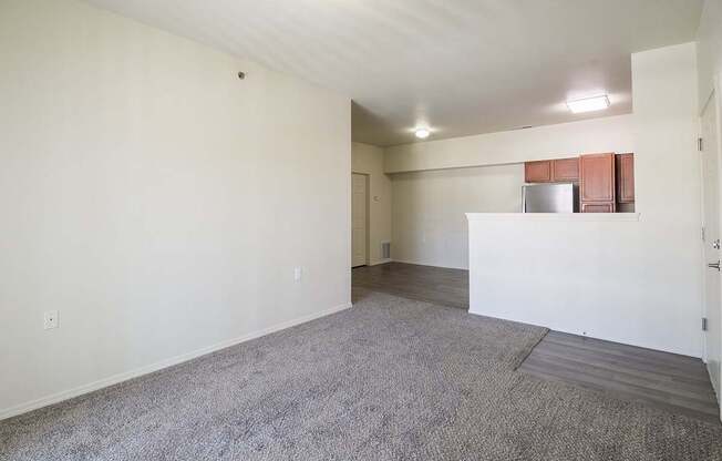 A large, empty room with a carpeted floor and white walls.