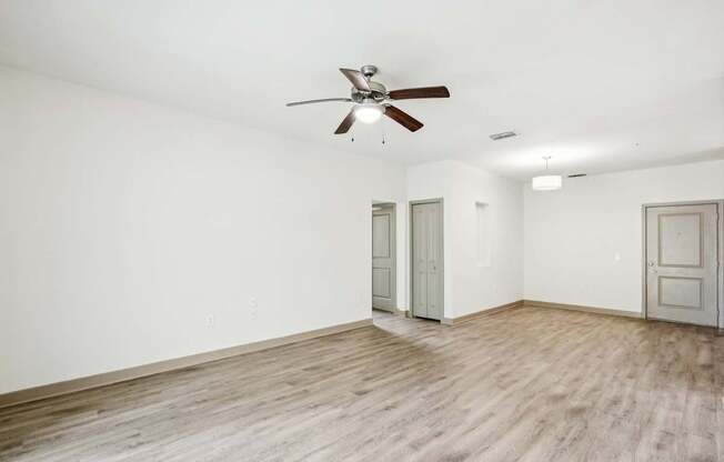 A room with a ceiling fan and wooden flooring at Oakleaf Plantation Apartments in Jacksonville, FL