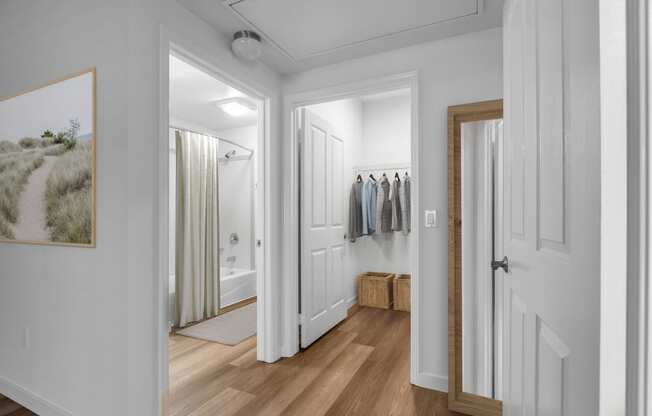 a hallway with a door to a closet and a bathroom with a shower