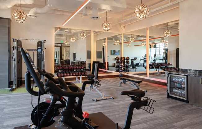 A gym with a variety of exercise equipment including treadmills, stationary bikes, and weight machines.