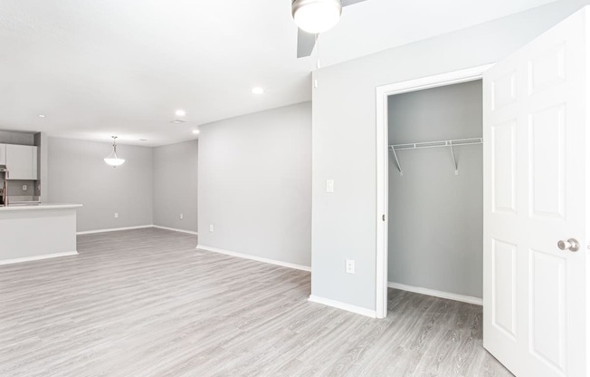 an empty living room with a closet and a kitchen at Parc at 1875, Georgia
