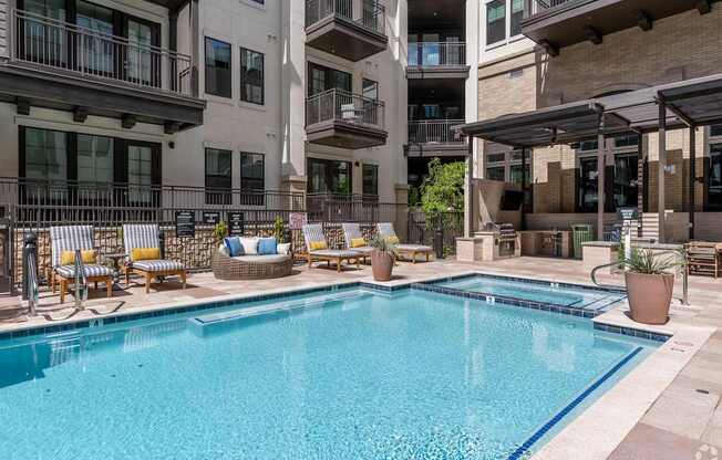 A large swimming pool in front of apartment buildings.