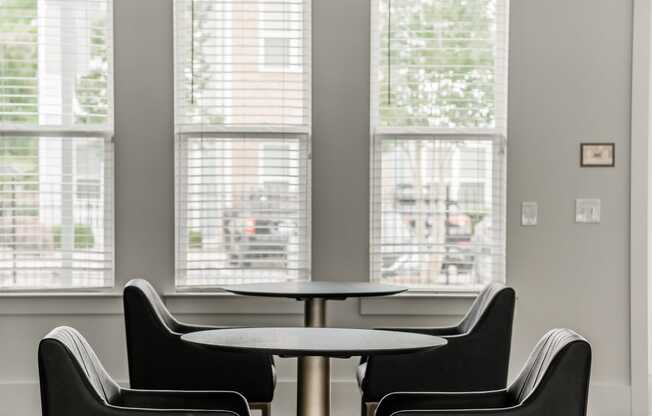 a dining room with chairs and a table and large windows