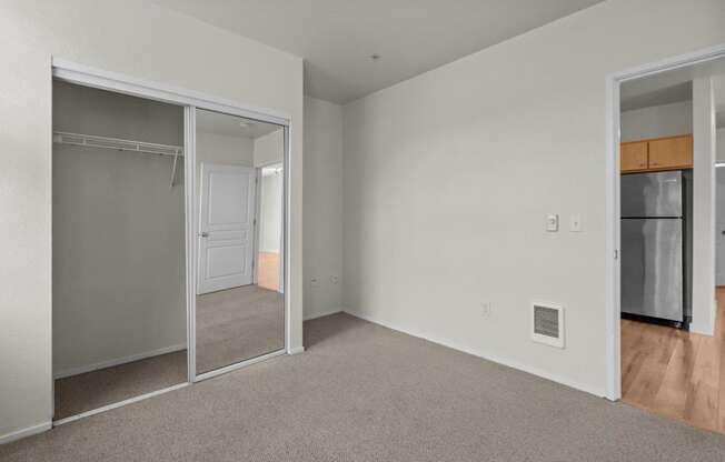 a bedroom with a closet and a mirrored door