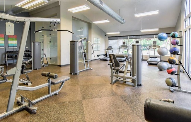 A gym with a variety of equipment including weights and machines.