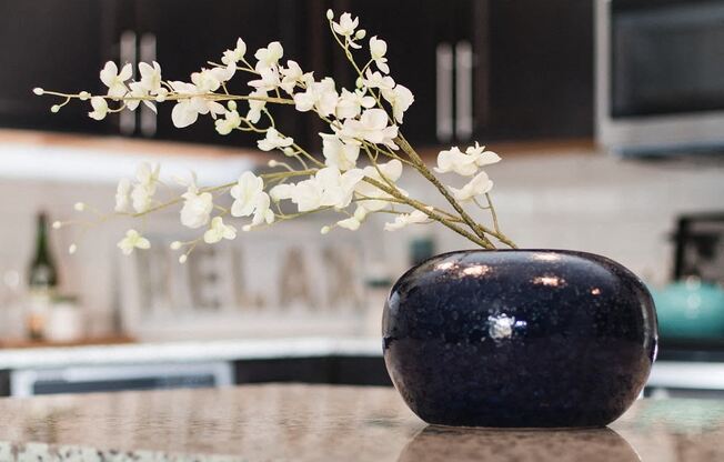 A vase with white flowers sits on a table.