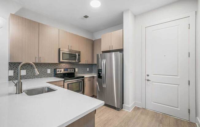 A kitchen with a sink, stove, and refrigerator.